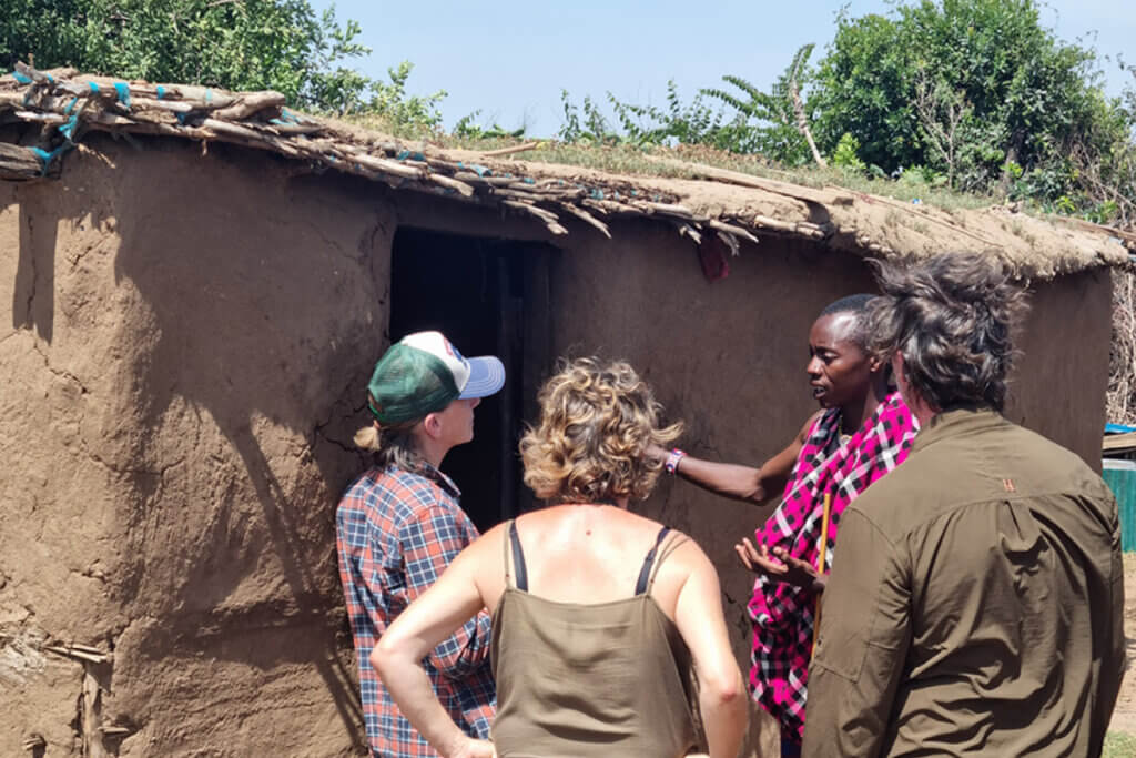 What to Expect on African Safari Tours in East Africa Ebonjalo tourists getting a house tour in Masai Mara Kenya during a Kenya Safari Tour