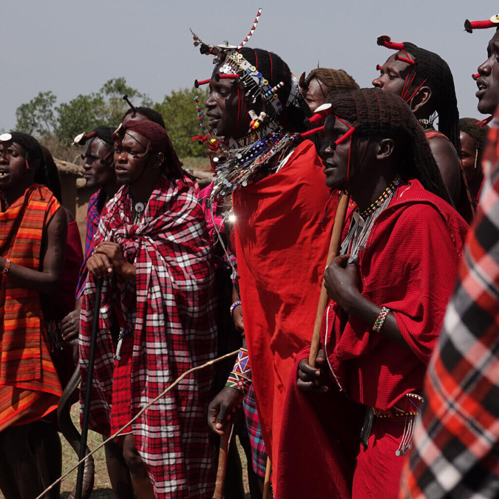 12 Day Kenya and Uganda Safari: Masai Mara & Karamoja Masaai men are dancing and jumping in their village in Masai Mara giving the visitors an authentic insight in their lives