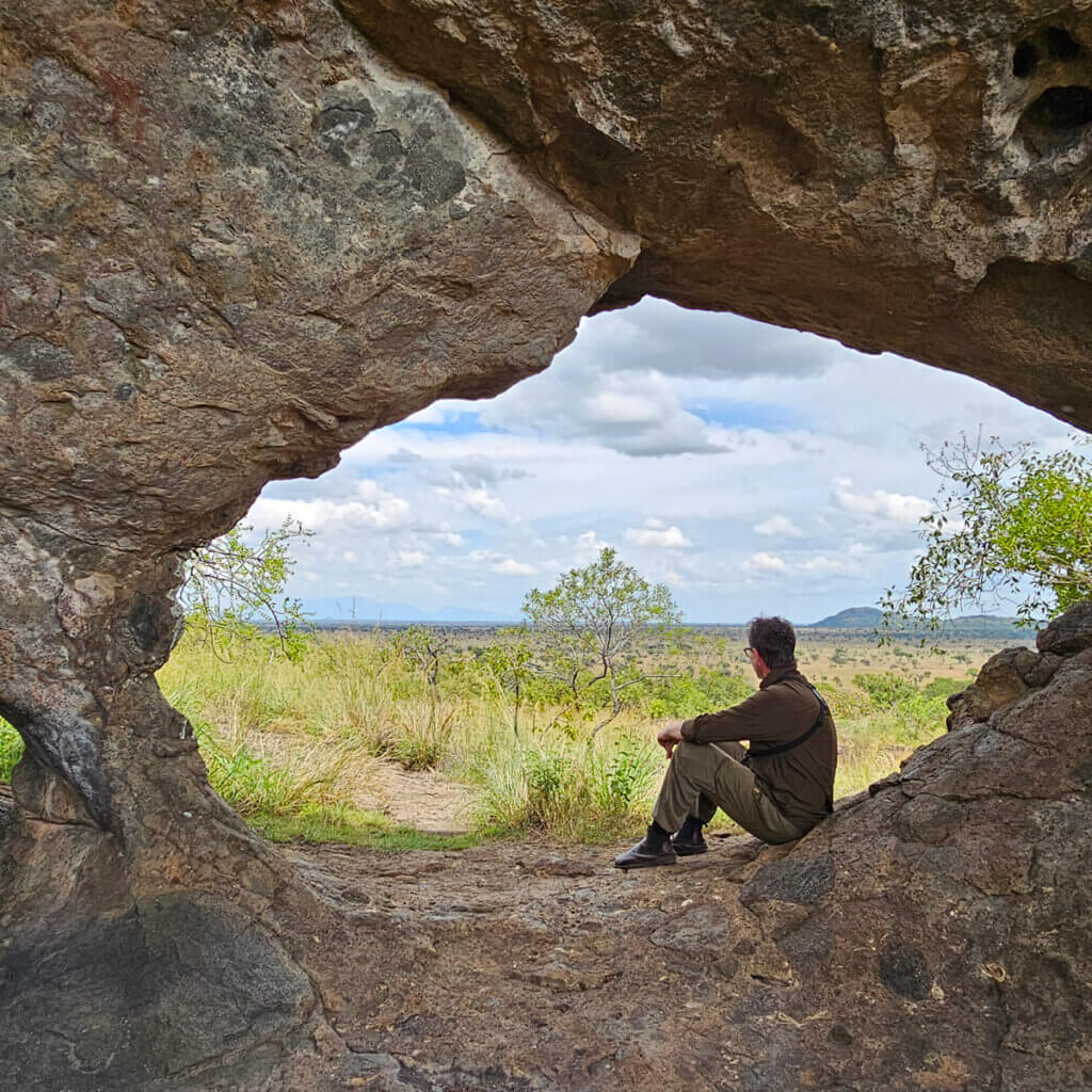 12 Day Kenya and Uganda Safari: Masai Mara & Karamoja Tourist of Ebonjalo overlooking the savannah from Napadet Cave in Pian Upe Wildlife Reserve